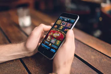 উৎসবের মুহূর্তে ঐতিহ্যবাহী পোশাক পরা এক আনন্দিত নারী তার স্মার্টফোন ব্যবহার করছেন, যা দেখায় 4777BTE অ্যাপ কীভাবে দৈনন্দিন জীবনের সঙ্গে সহজে মানিয়ে যায়।